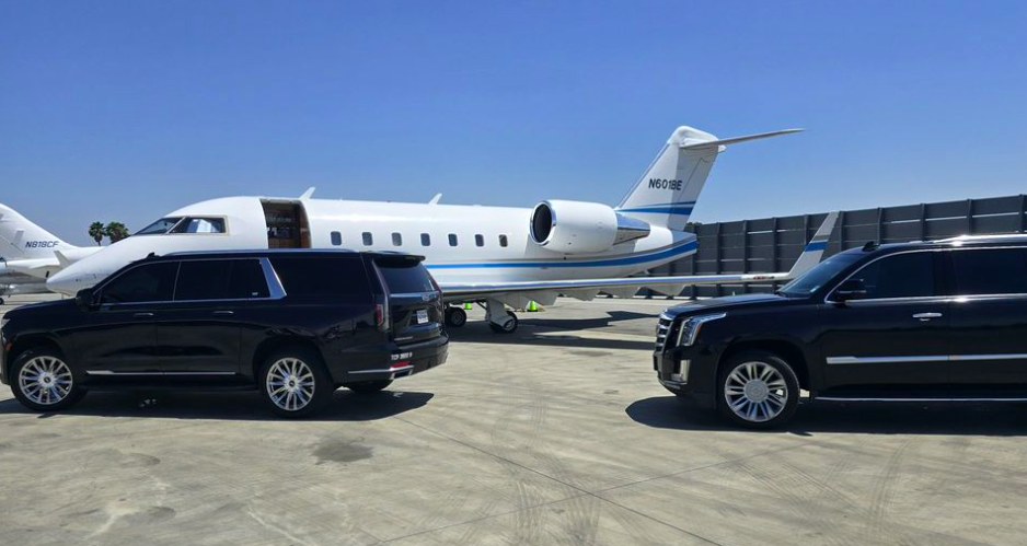 Black Cadillac Escalades staged beside a private jet